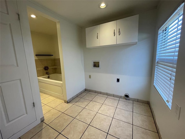 laundry area featuring washer hookup, cabinets, and light tile patterned floors