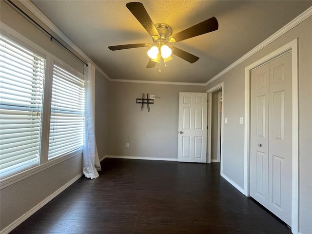 unfurnished room with dark hardwood / wood-style floors, ceiling fan, and crown molding