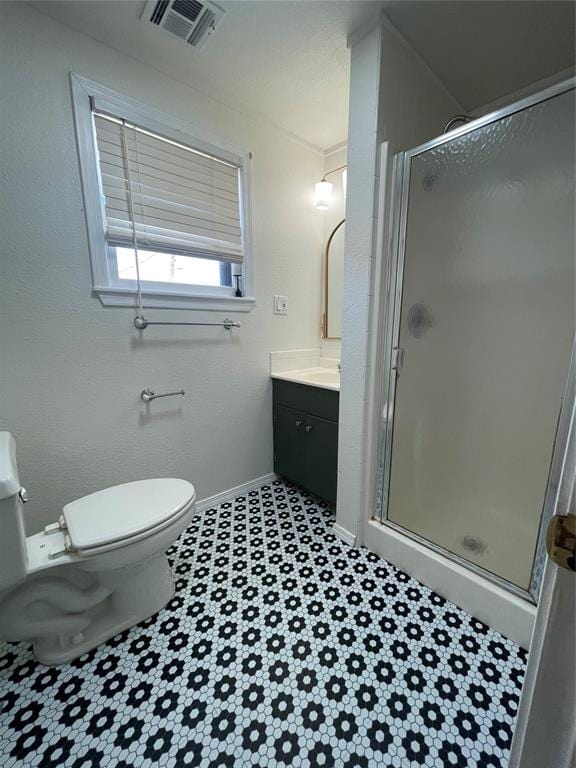 bathroom featuring vanity, toilet, and a shower with shower door