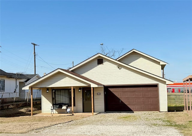 view of front facade featuring driveway, a garage, and fence