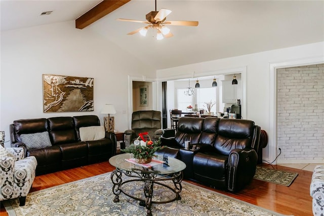 living room featuring vaulted ceiling with beams, ceiling fan, and wood-type flooring