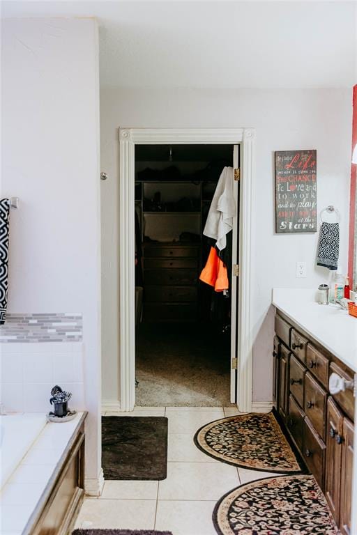 bathroom featuring a bathing tub, tile patterned flooring, and vanity