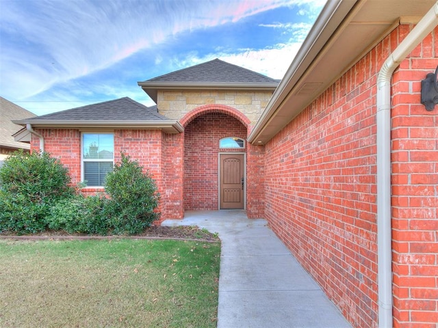 view of exterior entry with a lawn