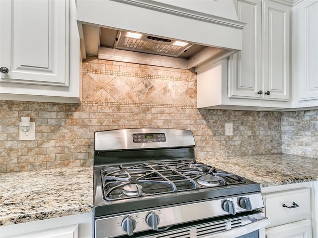 kitchen featuring decorative backsplash, white cabinetry, stainless steel range with gas cooktop, and premium range hood