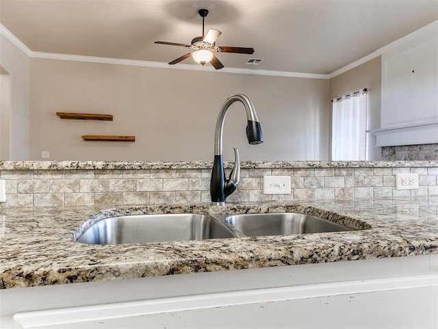 kitchen featuring tasteful backsplash, crown molding, and sink