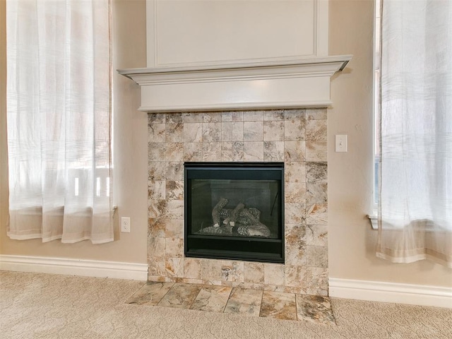 interior details with a tile fireplace and carpet