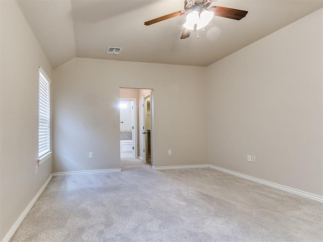 carpeted empty room with ceiling fan, a healthy amount of sunlight, and vaulted ceiling