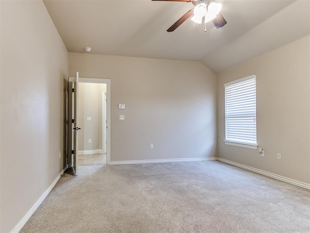 spare room with ceiling fan, light colored carpet, and lofted ceiling