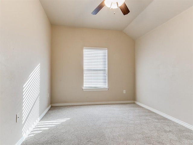 empty room featuring light carpet, vaulted ceiling, and ceiling fan