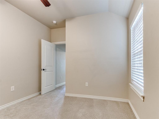 carpeted empty room with ceiling fan and lofted ceiling