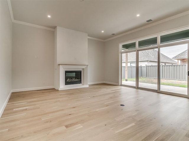 16413 Burgundy E Dr, Edmond, OK 73013 - unfurnished living room featuring ornamental molding, baseboards, light wood-style flooring, a glass covered fireplace, and recessed lighting