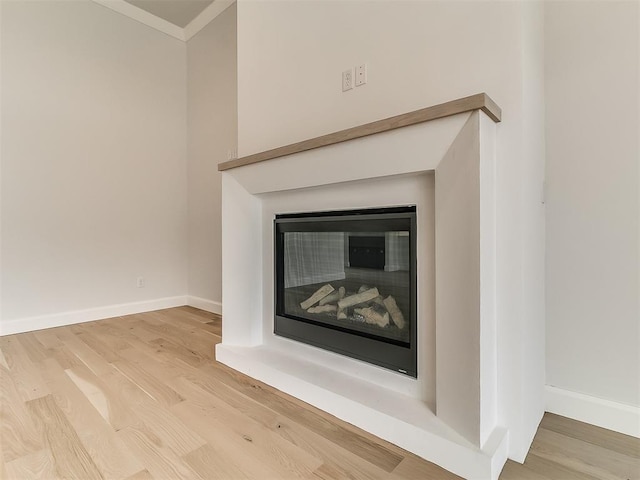16413 Burgundy E Dr, Edmond, OK 73013 - detailed view of wood finished floors, a glass covered fireplace, baseboards, and ornamental molding
