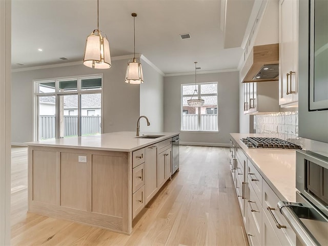 16413 Burgundy E Dr, Edmond, OK 73013 - kitchen featuring a sink, ornamental molding, light wood-type flooring, light countertops, and under cabinet range hood