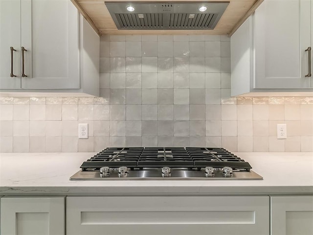 16413 Burgundy E Dr, Edmond, OK 73013 - kitchen featuring extractor fan, light countertops, stainless steel gas stovetop, tasteful backsplash, and white cabinets