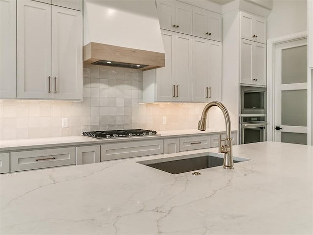16413 Burgundy E Dr, Edmond, OK 73013 - kitchen featuring stainless steel appliances, custom exhaust hood, a sink, and decorative backsplash