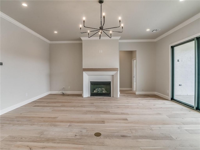 unfurnished living room featuring light hardwood / wood-style floors, ornamental molding, and a chandelier