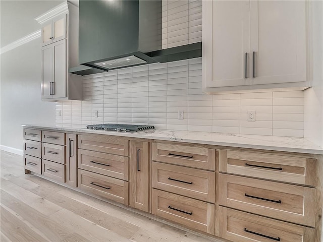 kitchen with decorative backsplash, light brown cabinetry, light wood-type flooring, and light stone countertops