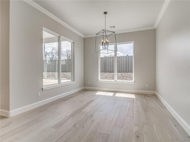 unfurnished dining area featuring a notable chandelier, crown molding, a wealth of natural light, and light hardwood / wood-style flooring