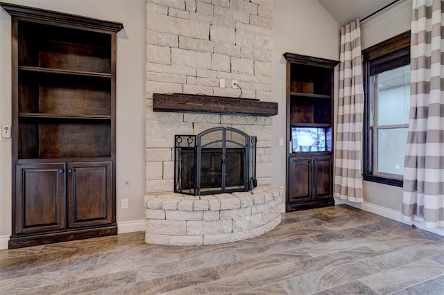 unfurnished living room featuring a stone fireplace and vaulted ceiling