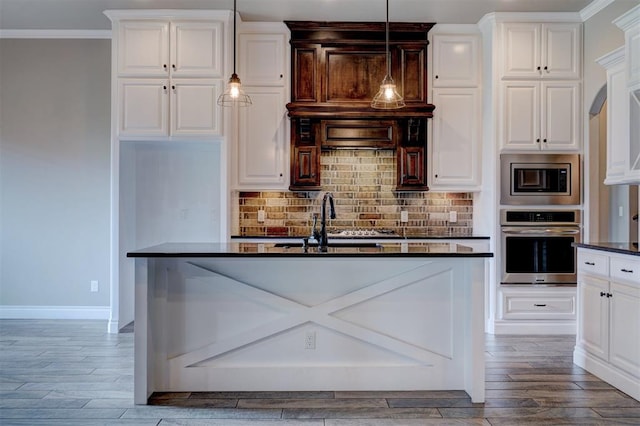 kitchen featuring decorative light fixtures, wood-type flooring, white cabinetry, and appliances with stainless steel finishes