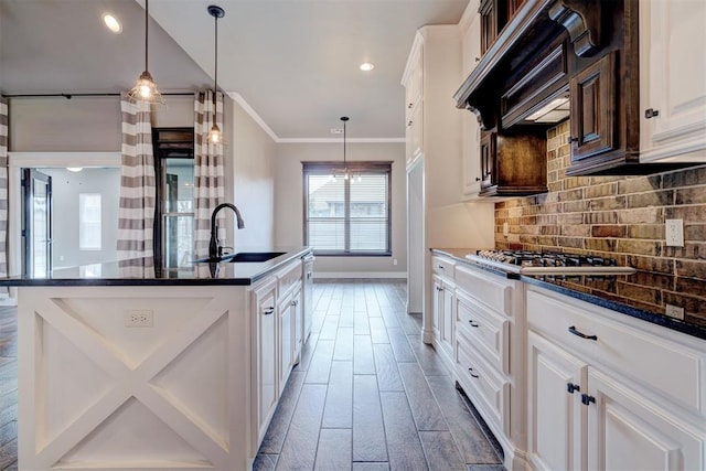 kitchen featuring backsplash, sink, dark hardwood / wood-style floors, white cabinetry, and an island with sink