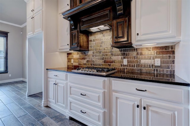 kitchen with stainless steel gas cooktop, tasteful backsplash, ornamental molding, white cabinets, and custom exhaust hood