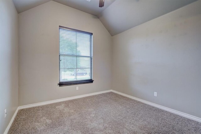 carpeted spare room featuring ceiling fan and lofted ceiling