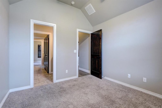 unfurnished bedroom with carpet floors and vaulted ceiling