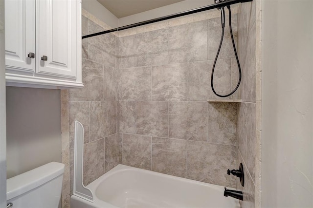 bathroom featuring toilet and tiled shower / bath