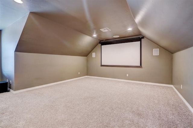 carpeted cinema room with lofted ceiling