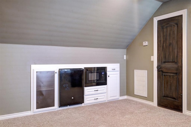 bonus room with light colored carpet and vaulted ceiling