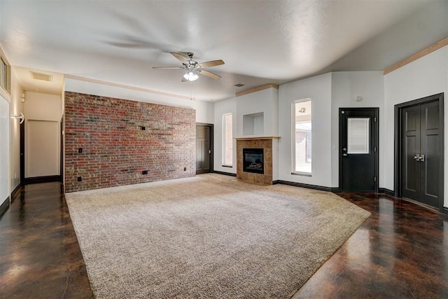 unfurnished living room featuring a fireplace, ceiling fan, and brick wall