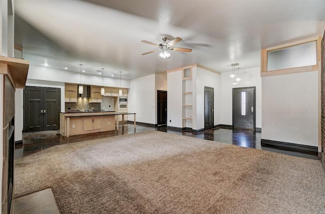 unfurnished living room featuring a fireplace and ceiling fan with notable chandelier