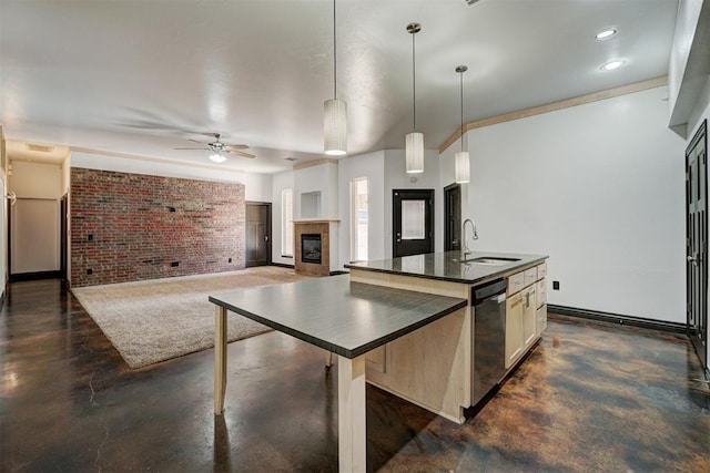 kitchen with sink, hanging light fixtures, brick wall, stainless steel dishwasher, and a kitchen island with sink