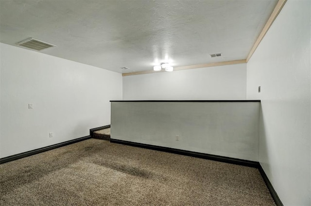 unfurnished room featuring carpet flooring, a textured ceiling, and ornamental molding