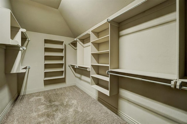 spacious closet with light carpet and vaulted ceiling