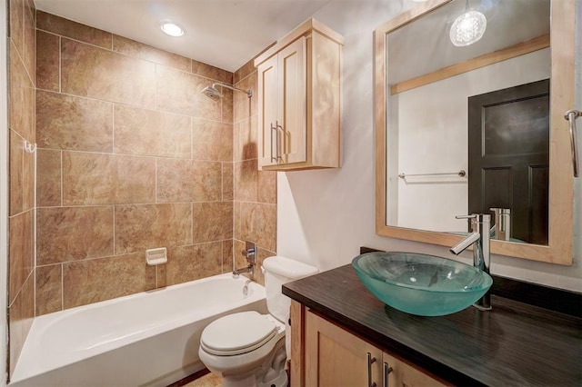 full bathroom featuring vanity, tiled shower / bath combo, and toilet