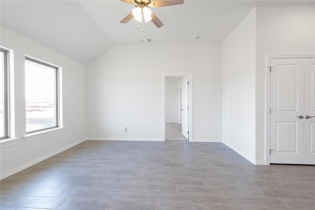 spare room featuring visible vents, baseboards, a ceiling fan, and lofted ceiling