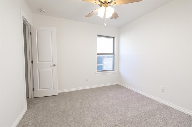carpeted empty room with ceiling fan and baseboards