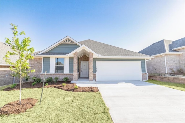 view of front of property with brick siding, an attached garage, a front lawn, and concrete driveway
