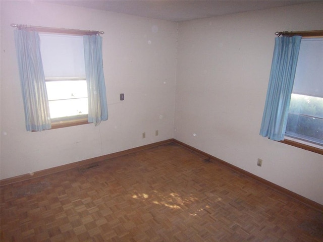 unfurnished room featuring dark parquet flooring