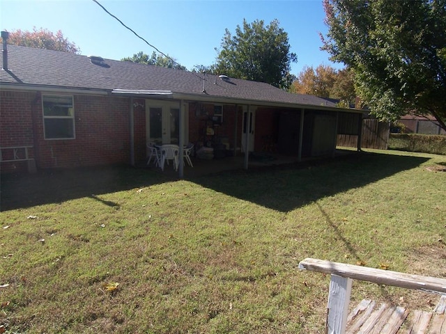 rear view of house featuring a yard