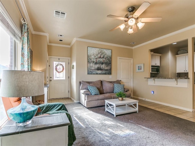 tiled living room featuring a wealth of natural light, crown molding, and ceiling fan