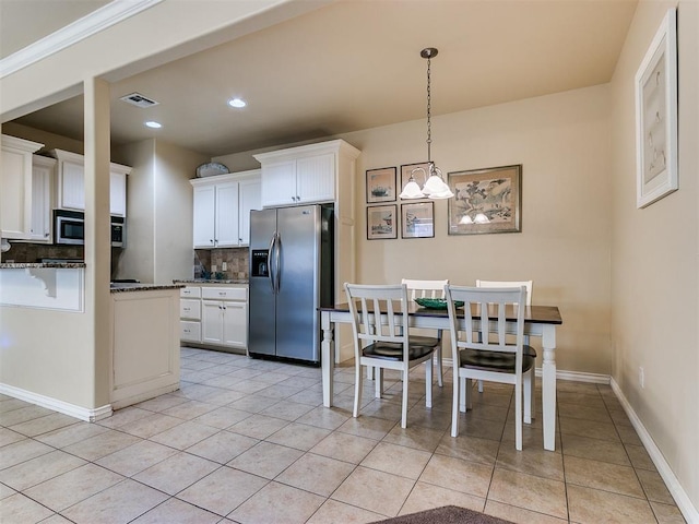 kitchen with white cabinets, backsplash, and appliances with stainless steel finishes