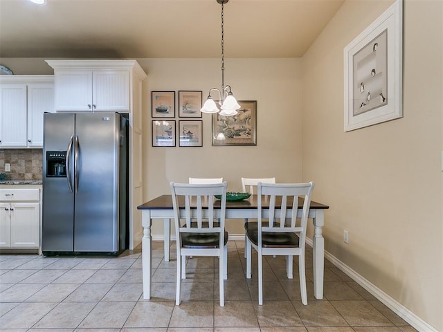 dining area featuring a chandelier and light tile patterned flooring