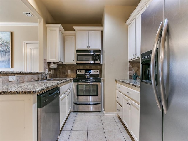 kitchen featuring stone counters, white cabinets, appliances with stainless steel finishes, tasteful backsplash, and light tile patterned flooring