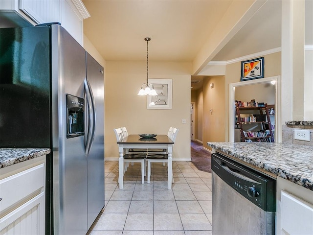 kitchen featuring white cabinetry, hanging light fixtures, stainless steel appliances, a notable chandelier, and light tile patterned floors