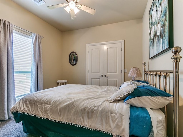 carpeted bedroom with ceiling fan and a closet