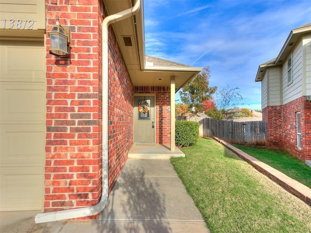 view of exterior entry with a yard