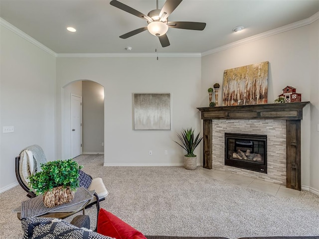 carpeted living room with ceiling fan, ornamental molding, and a fireplace